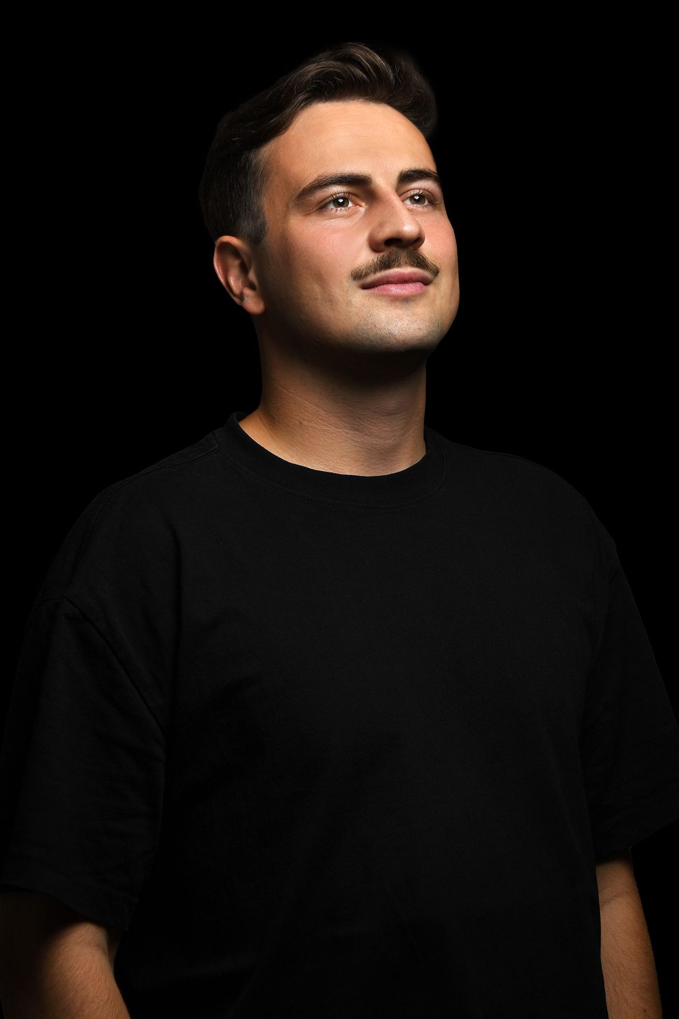 Portrait of Luca Dario in a black T-shirt against a black background
